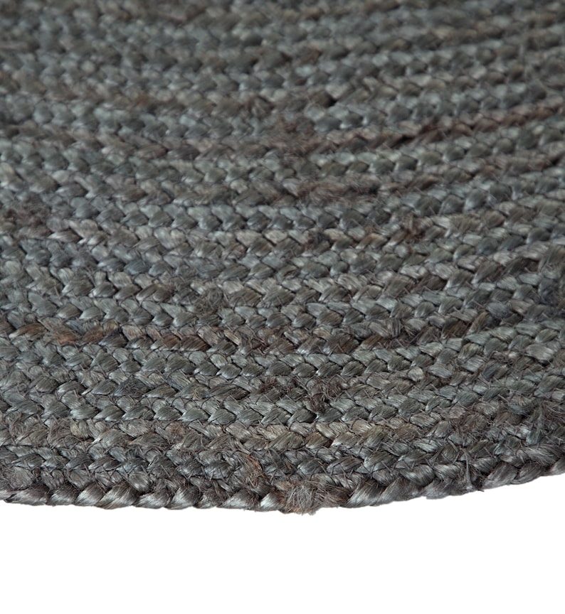 May include: A close-up of a round, gray jute rug with a woven texture.