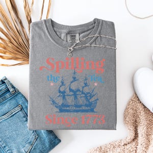 May include: Gray t-shirt with a vintage-style graphic of a ship and the text "Spilling the Tea Since 1773".
