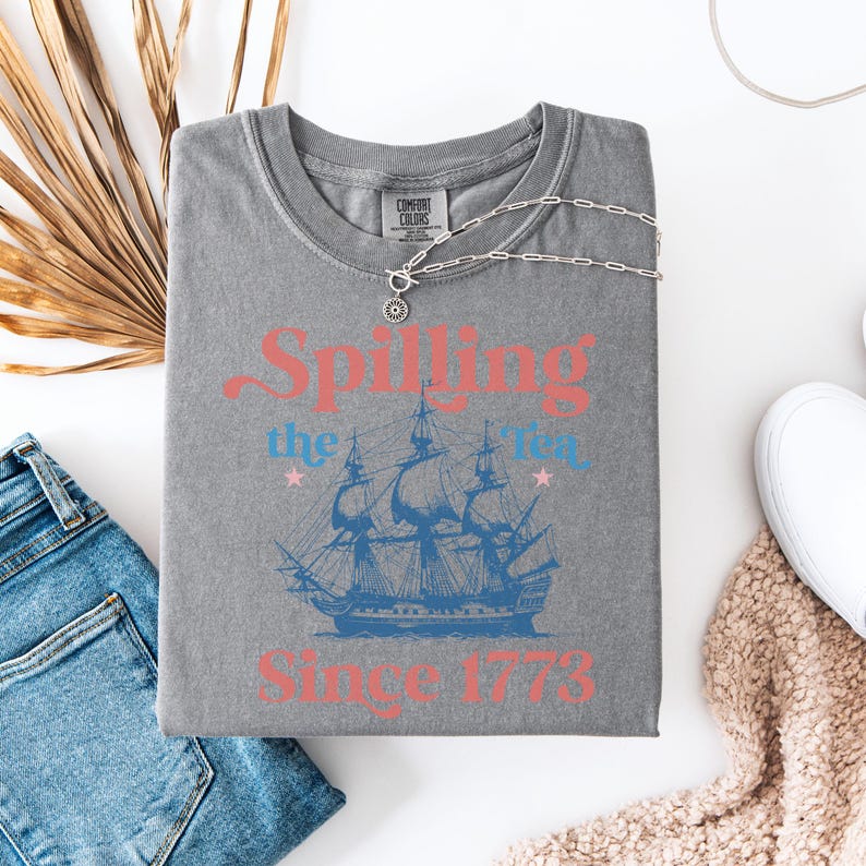 May include: Gray t-shirt with a vintage-style graphic of a ship and the text "Spilling the Tea Since 1773".