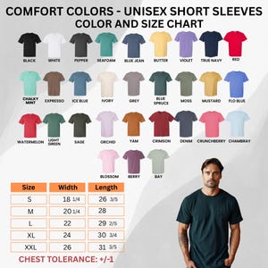 May include: Color chart for unisex short sleeve t-shirts. The chart displays various colors, including black, white, and red. Size chart shows measurements in inches for width and length. A man is wearing a dark green t-shirt.