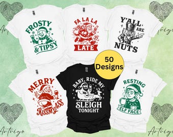 Può includere: Una collezione di magliette grafiche bianche e nere con disegni a tema natalizio. Le magliette presentano varie illustrazioni e testo, tra cui un pupazzo di neve, Babbo Natale ed elfi. Il testo include frasi come "Frosty & Tipsy" e "Y'all are Nuts."
