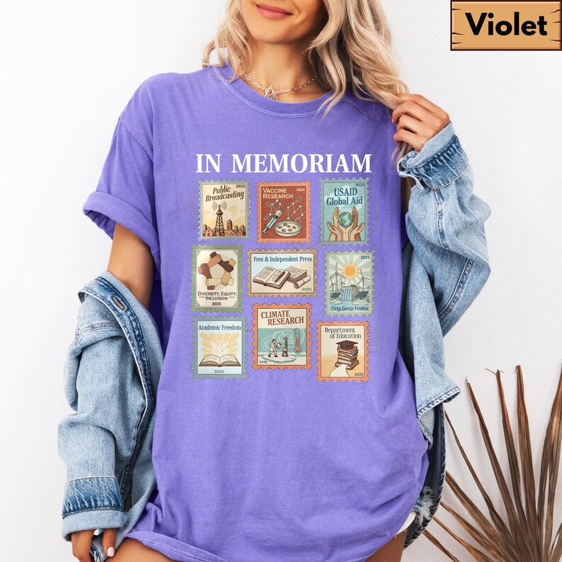 May include: A violet-colored t-shirt with the words "IN MEMORIAM" above a collection of postage stamp-style graphics. The stamps depict various themes, including "Public Broadcasting," "Vaccine Research," and "Climate Research."