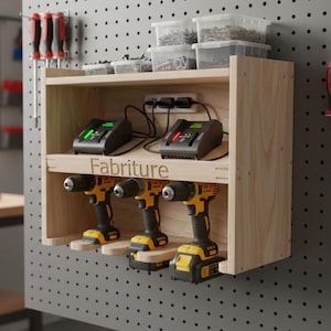 May include: Wooden drill organiser with three yellow and black drills, two chargers, and storage for small parts. The organiser is mounted on a pegboard, with the word "Fabriture" visible.