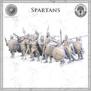 May include: A group of Spartan warriors, each holding a spear and shield, are depicted in a battle formation. The figures are in a neutral color, with helmets and armor. The word "SPARTANS" is displayed at the top of the image, with the Games Mythology logo.