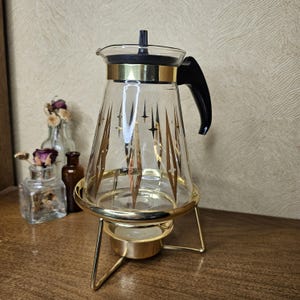 1950年代のパイレックス アトミックガラス カラフェ – ゴールドスターバースト、オリジナルキャンドルウォーマー付き – ミッドセンチュリー未使用コーヒーサーバー