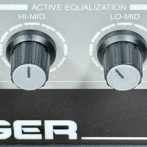 May include: Close-up of an audio equipment control panel with two black knobs labeled "HI-MID" and "LO-MID" for active equalization. The panel is gray with white text and a black base with the word "GER" in white.