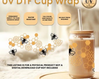 Op de afbeelding: Een glazen beker met een bamboe deksel en rietje, versierd met bijen- en honingraatpatronen. De beker bevat een lichtgekleurde drank. De tekst "UV DTF Cup Wrap" is zichtbaar. De aanbieding is voor een fysiek product.