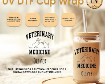Op de afbeelding: Een heldere glazen beker met een bamboe deksel en rietje, met een UV DTF-wikkel. De wikkel toont de tekst "VETERINARY MEDICINE" met een honden- en kattenafbeelding, en de naam "OLIVER". De beker is waterbestendig en vereist geen hittepers.