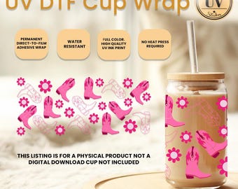 Op de afbeelding: Een doorzichtige glazen beker met een roze en wit cowboylaarsontwerp. De beker heeft een houten deksel en een rietje. De tekst "UV DTF Cup Wrap" staat bovenaan de afbeelding.