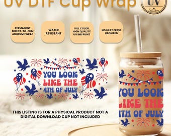 Op de afbeelding: Een glazen beker met een bamboe deksel en rietje, met een patriottisch 4 juli-ontwerp. Het ontwerp bevat vuurwerk, ballonnen en de tekst "YOU LOOK LIKE THE 4TH OF JULY". Het is een UV DTF cup wrap.
