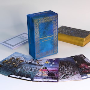 May include: A blue box with gold accents and the text "Oceanum Arcanae The Ocean Tarot" on the front. The box is open and shows a deck of tarot cards with illustrations of a castle, a star, swords, and a monster.