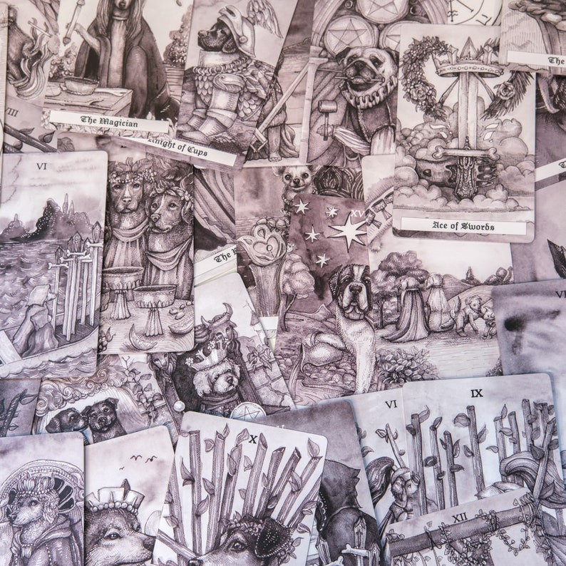 May include: A collection of tarot cards featuring black and white illustrations of dogs and other animals. The cards are arranged in a random order, with some cards partially visible. The cards include the Ace of Swords, The Magician, Knight of Cups, and others.