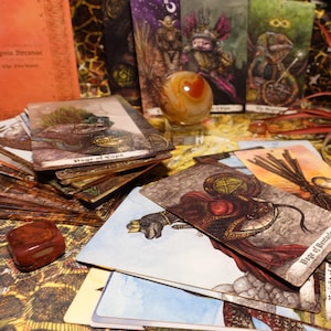 May include: A spread of tarot cards featuring illustrations of fantastical creatures and symbols. The cards are arranged on a surface with a brown and orange patterned background. The cards include "Page of Cups", "Page of Pentacles", "The Magician", and "The Star".