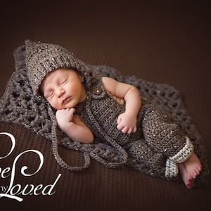 May include: A newborn baby is sleeping soundly in a brown crocheted outfit and hat. The baby is lying on a brown crocheted blanket. The image is captioned "Live Loved Photography".