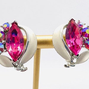 May include: A pair of silver tone clip-on earrings with a large pink marquise shaped rhinestone and smaller iridescent rhinestones.