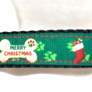 Peut inclure: Collier de chien vert avec une boucle noire et un os blanc sur lequel est imprimé "Merry Christmas". Le collier présente également des empreintes de pattes, une chaussette et un nœud.