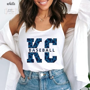May include: White tank top with a blue and white leopard print "KC Baseball" graphic.