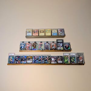 18 inch trading card shelf with Pokemon cards on display mounted to the wall. 24 in sports card shelf with PSA slab cards on display mounted to the wall.  36"  football, baseball, soccer, hockey, and basketball cards displayed on a wall mounted shelf mounted to the wall.  All displays can be used on a desk, nightstand or shelf.
