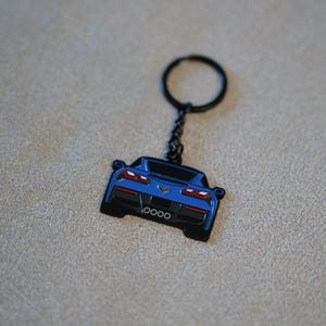 Op de afbeelding: Een set van drie keramische mokken met een gespikkelde, matte afwerking. De mokken zijn in crème, lichtgrijs en donkergrijs. Elke mok heeft een eenvoudig, minimalistisch ontwerp en een afgeronde handgreep.