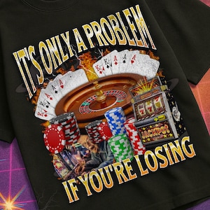 Könnte beinhalten: Schwarzes T-Shirt mit einem Casino-Motiv. Das Design zeigt ein Roulette-Rad, Spielkarten, Pokerchips und den Text "IT'S ONLY A PROBLEM IF YOU'RE LOSING". Das T-Shirt hat einen Retro-Look.