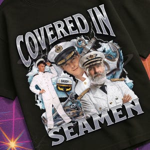 May include: Black t-shirt with a graphic featuring the text "COVERED IN SEAMEN" above a collage of men in naval uniforms. The shirt also has the text "MILDLY PERTURBED" at the bottom, with a retro VHS and space-themed background.