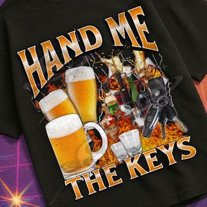Op de afbeelding: Zwart T-shirt met de tekst "HAND ME THE KEYS" boven een afbeelding van bierglazen en flessen. Het shirt maakt deel uit van de "Mildly Perturbed" collectie, met een retro VHS en ruimtevaart thema.