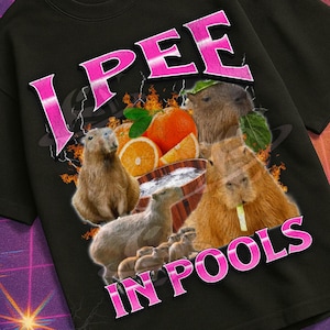 Può includere: T-shirt nero con la scritta rosa "I PEE IN POOLS", con una grafica di capibara, arance e una ciotola. La maglietta fa parte della collezione "Mildly Perturbed", con un'estetica VHS retrò.