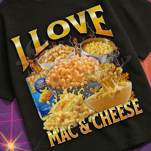 以下が含まれることがあります： 様々なマック＆チーズ料理のグラフィックと「I LOVE MAC & CHEESE」の文字が入った黒いTシャツ。「Mildly Perturbed」コレクションの一部で、レトロなVHSと宇宙をテーマにしたデザインです。