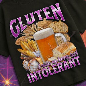 May include: Black t-shirt with a graphic design featuring the word "GLUTEN" in a purple, stylized font, along with images of bread, beer, and fries. The text "...it makes my tummy feel INTOLERANT" is also included.