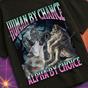 Può includere: T-shirt nera con grafica di lupi e la scritta "HUMAN BY CHANCE ALPHA BY CHOICE". Il design ha un'estetica retrò, con una cassetta VHS e il logo "Mildly Perturbed".