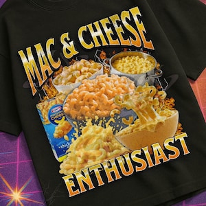 May include: Black t-shirt with a graphic of various mac and cheese dishes and the words "MAC & CHEESE ENTHUSIAST" in yellow and orange. The shirt is part of the "Mildly Perturbed" collection.