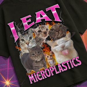 May include: Black t-shirt featuring a cat graphic and the pink text "I EAT MICROPLASTICS". The design has a retro style, with a "Mildly Perturbed" logo and a VHS tape graphic, evoking a vintage aesthetic.