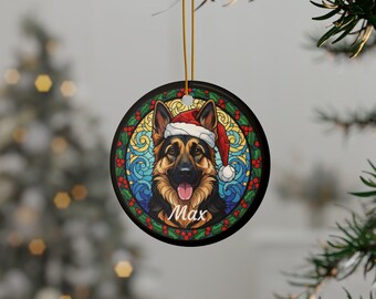 May include: Round Christmas ornament featuring a German Shepherd wearing a Santa hat. The dog's portrait is set against a stained-glass style background with the name "Max" below. The ornament is hanging from a gold string.