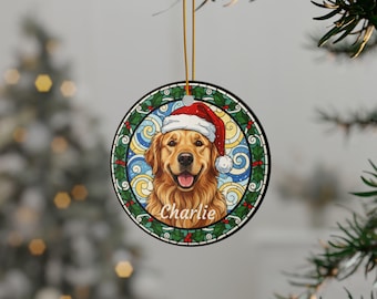 May include: Round Christmas ornament featuring a Golden Retriever wearing a Santa hat. The dog's name, "Charlie," is written below. The ornament has a stained-glass style border with holly and berries. A gold string is attached for hanging.