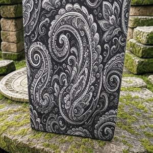 May include: A black and white paisley patterned notebook cover. The cover has a textured, embossed design.