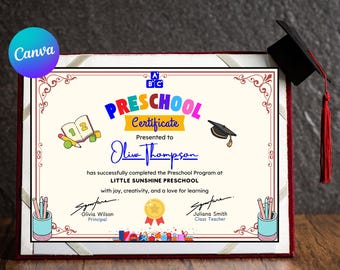 May include: A framed preschool certificate with a black graduation cap and red tassel. The certificate has the words "Preschool Certificate" in colorful letters, and the name "Olive Thompson" is written in cursive. The certificate is decorated with pencils, a book, and a gold medal.