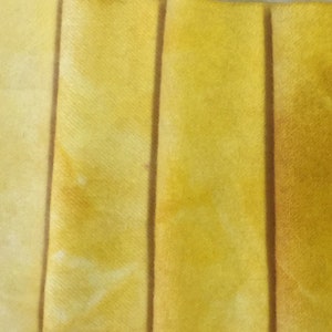 May include: A collection of fabric strips in various shades of yellow, ranging from pale to deep, showcasing a gradient of color.