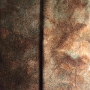 May include: Two pieces of fabric dyed in shades of brown, green, and beige. The fabric has a mottled, tie-dye effect.