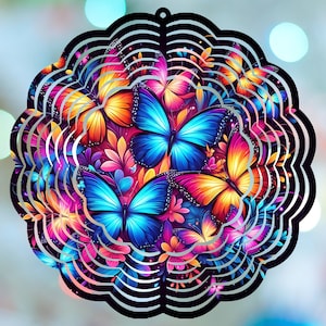 May include: A colorful, circular metal wind spinner featuring a vibrant butterfly design. The butterflies have blue, orange, and pink wings, surrounded by floral accents. The spinner has a black, scalloped edge and a silver, layered design.