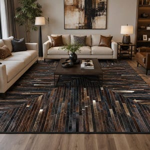 Puede incluir: Una alfombra rectangular grande con un patrón geométrico de tiras verticales estrechas en varios tonos de marrón, negro, gris y blanco. La alfombra está compuesta por paneles texturizados dispuestos en un diseño de espiga en el suelo.