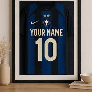 Puede incluir: Una camiseta de fútbol negra y azul enmarcada con un logotipo Nike swoosh dorado, un escudo de equipo dorado y el texto "YOUR NAME" y "10" en dorado.