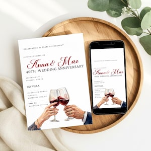 May include: A white invitation card and a smartphone display the text "Anna & Max 40th Wedding Anniversary." The invitation features two wine glasses clinking, with the event details. The smartphone shows the same design.
