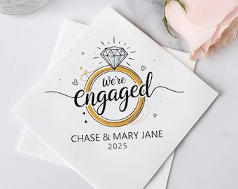 May include: White paper napkins with a gold ring design and a diamond. The text reads "We're engaged" with the names "Chase & Mary Jane" and the year "2025". The design includes small hearts.