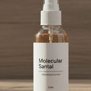 Puede incluir: Un frasco de spray de fragancia de vidrio transparente con una etiqueta blanca que dice "Molecular Santal FRAGRANCE SPRAY 25ML". El l&iacute;quido del interior es de color marr&oacute;n claro. El frasco tiene un pulverizador y una tapa blancos.