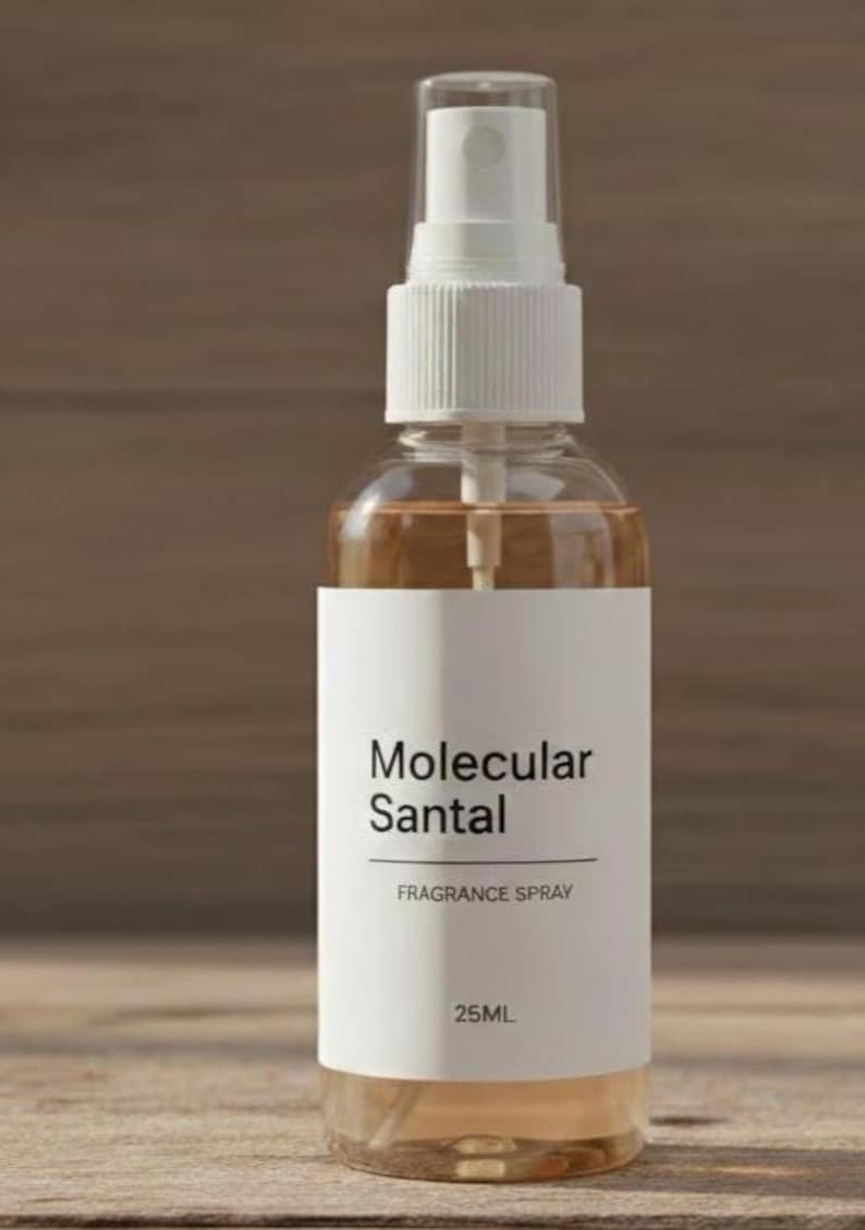 Puede incluir: Un frasco de spray de fragancia de vidrio transparente con una etiqueta blanca que dice "Molecular Santal FRAGRANCE SPRAY 25ML". El l&iacute;quido del interior es de color marr&oacute;n claro. El frasco tiene un pulverizador y una tapa blancos.