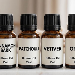 May include: Six amber glass diffuser oil bottles with black caps and white labels. The labels read "CARDAMOM", "CINNAMON BARK", "PATCHOULI", "VETIVER", "ORRIS", and "VIOLET LEAF". Each bottle contains 15mL of oil.
