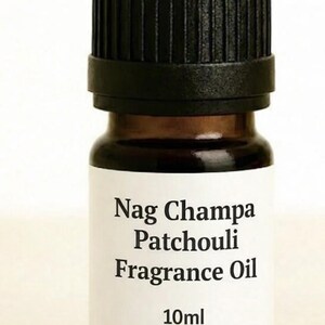 May include: A small, brown glass bottle of Nag Champa Patchouli Fragrance Oil with a black cap. The label displays the product name and the volume, 10ml.