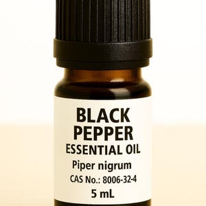 May include: A small, brown glass bottle of black pepper essential oil with a black cap. The label reads "BLACK PEPPER ESSENTIAL OIL" and lists the plant's scientific name, CAS number, and volume of 5 mL.
