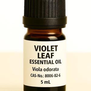 May include: A small amber glass bottle with a black cap, labeled "VIOLET LEAF ESSENTIAL OIL." The label also includes "Viola odorata," CAS-No., and "5 mL."