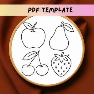 May include: A PDF template for embroidery featuring line drawings of an apple, pear, cherries, and a strawberry. The design is inside a wooden embroidery hoop. The text "PDF TEMPLATE" is at the top.